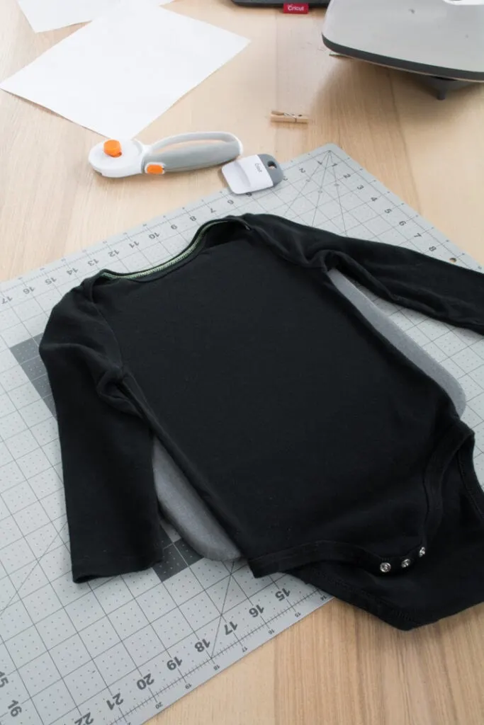 black baby bodysuit on a table
