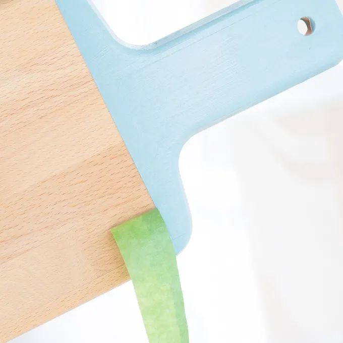 removing painter's tape from the painted cutting board