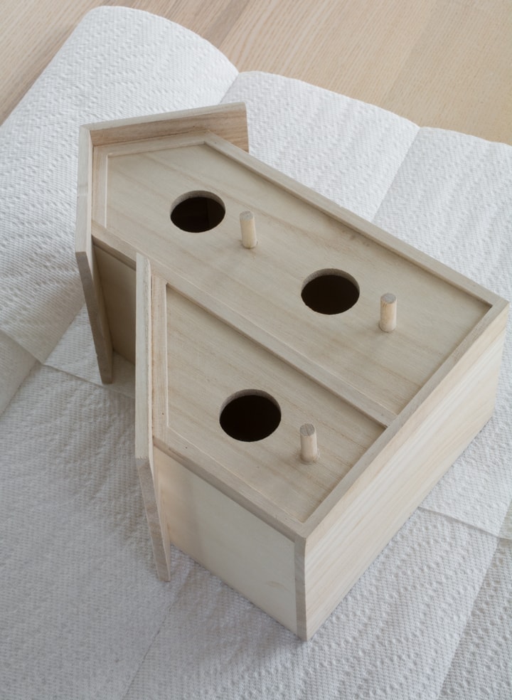 unfinished wooden birdhouse on a table