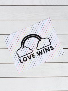 piece of paper that says LOVE WINS on rainbow hearts