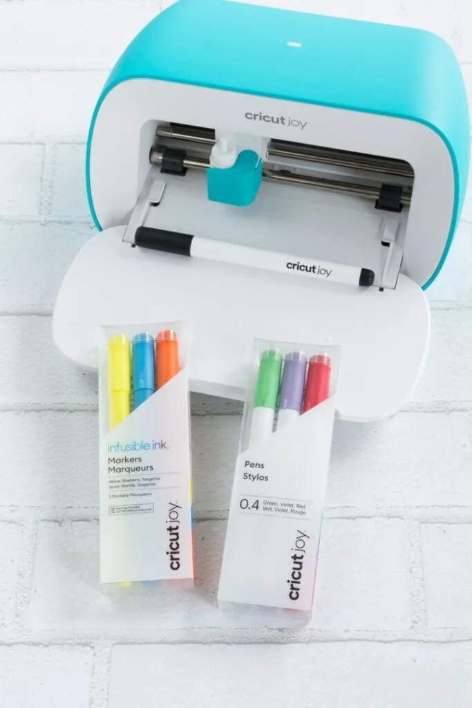 Cricut joy machine and pens in packages