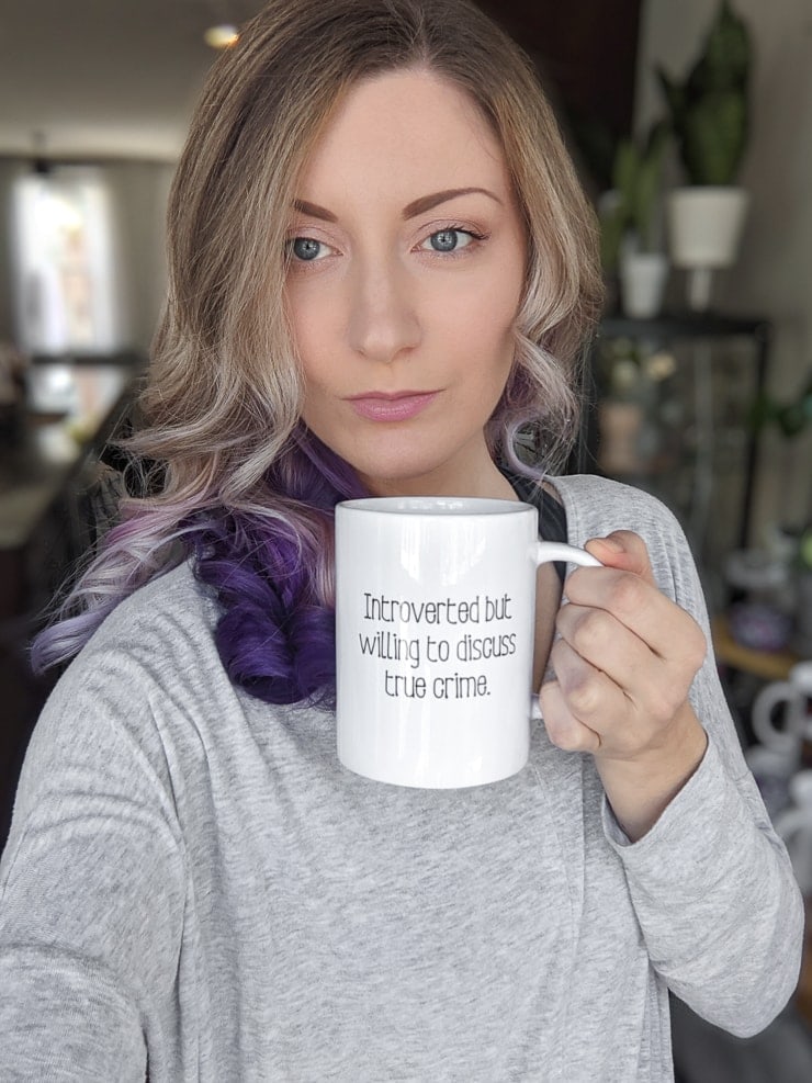 woman with a mug that says introverted but willing to discuss true crime made on a Cricut mug Press