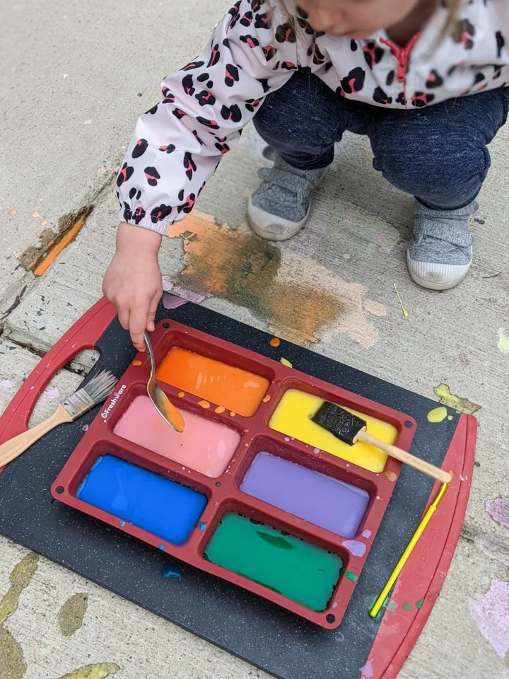 painting DIY sidewalk chalk paint using a paint brush