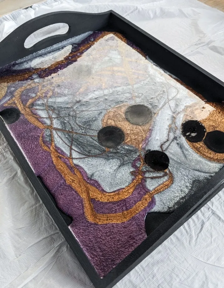 pouring colored resin into a painted tray