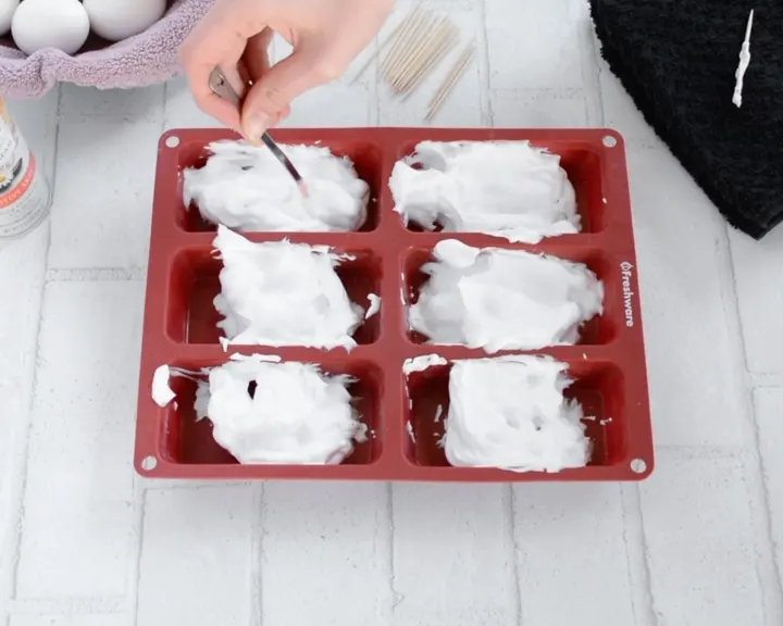 adding shaving cream to a muffin pan