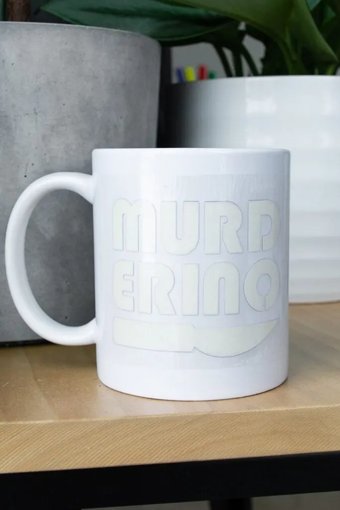 Infusible Ink transfer sheet on a mug that says "murderino"