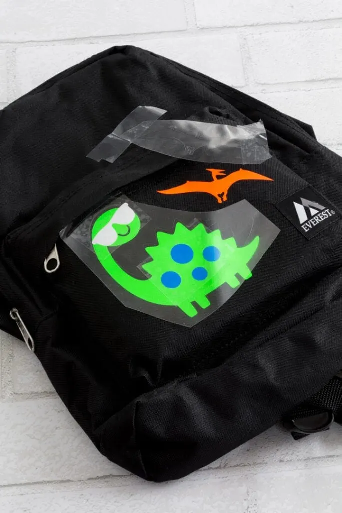 transferring dinosaurs cut out of vinyl to the backpack