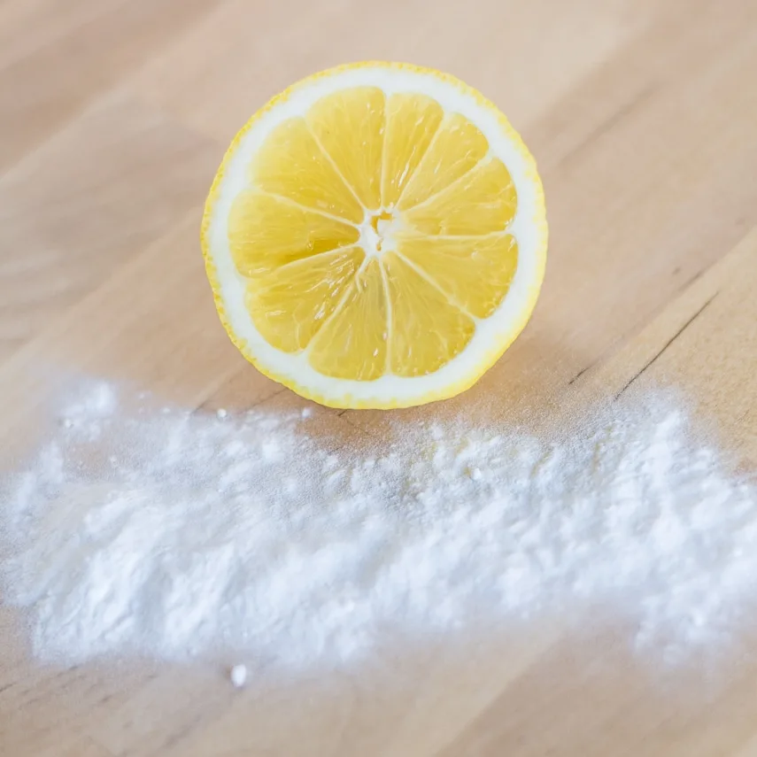 half of a lemon and baking soda on a table