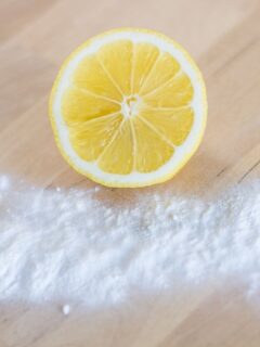 half of a lemon and baking soda on a table