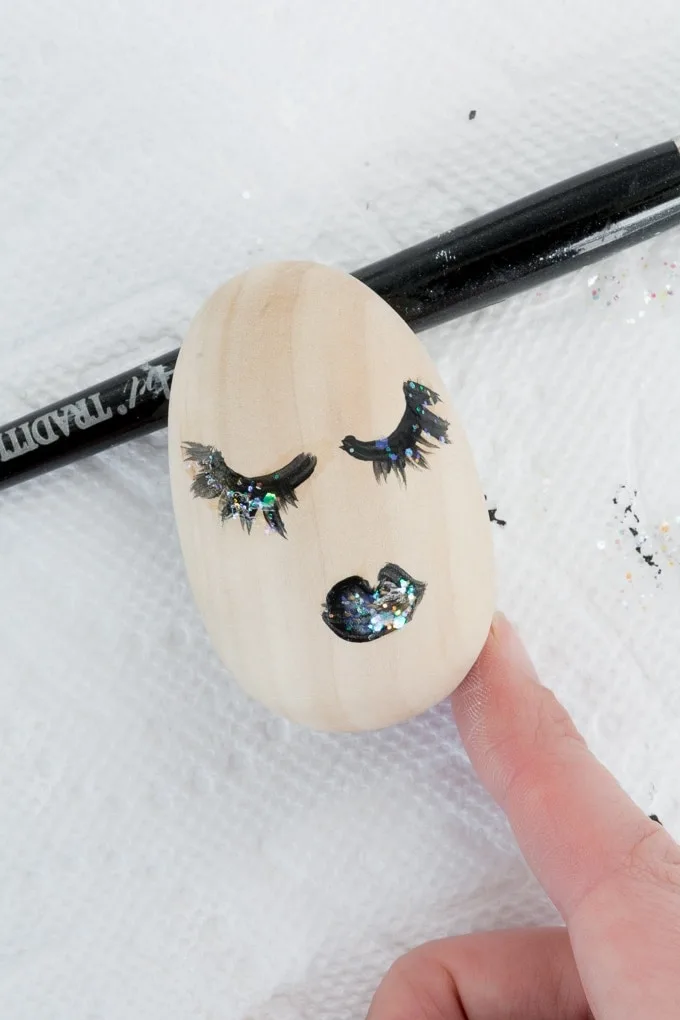 wooden egg with a face painted on it