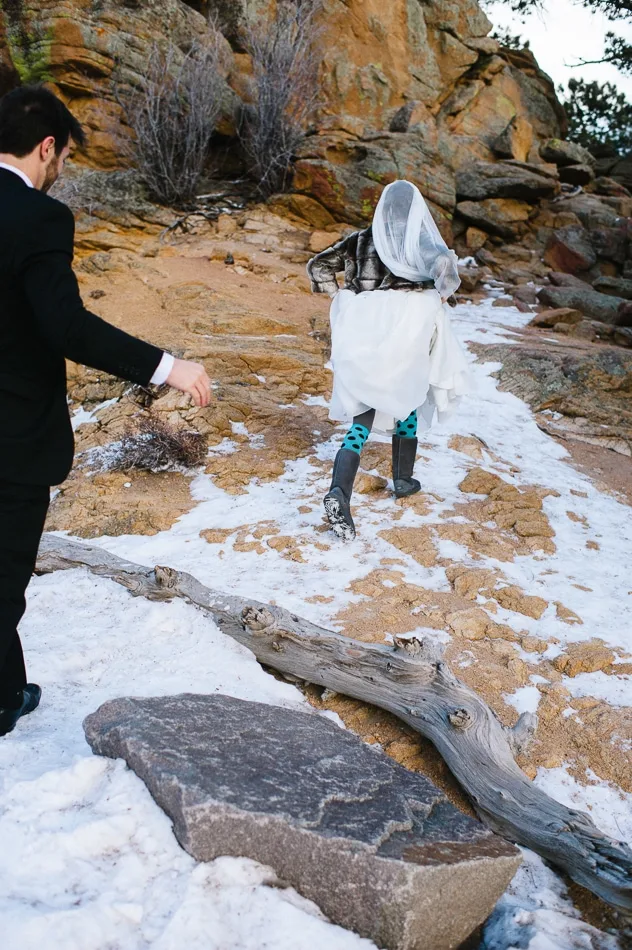 woman in a wedding dress walking up a snowy mountain