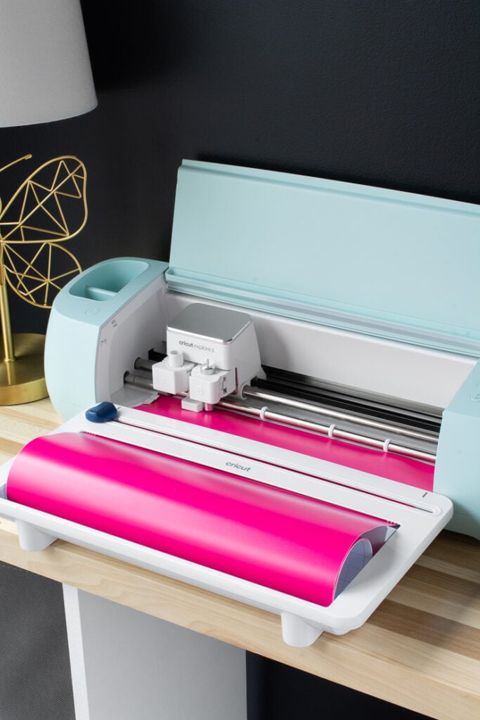 Cricut Explore 3 cutting bright pink vinyl with a roll holder