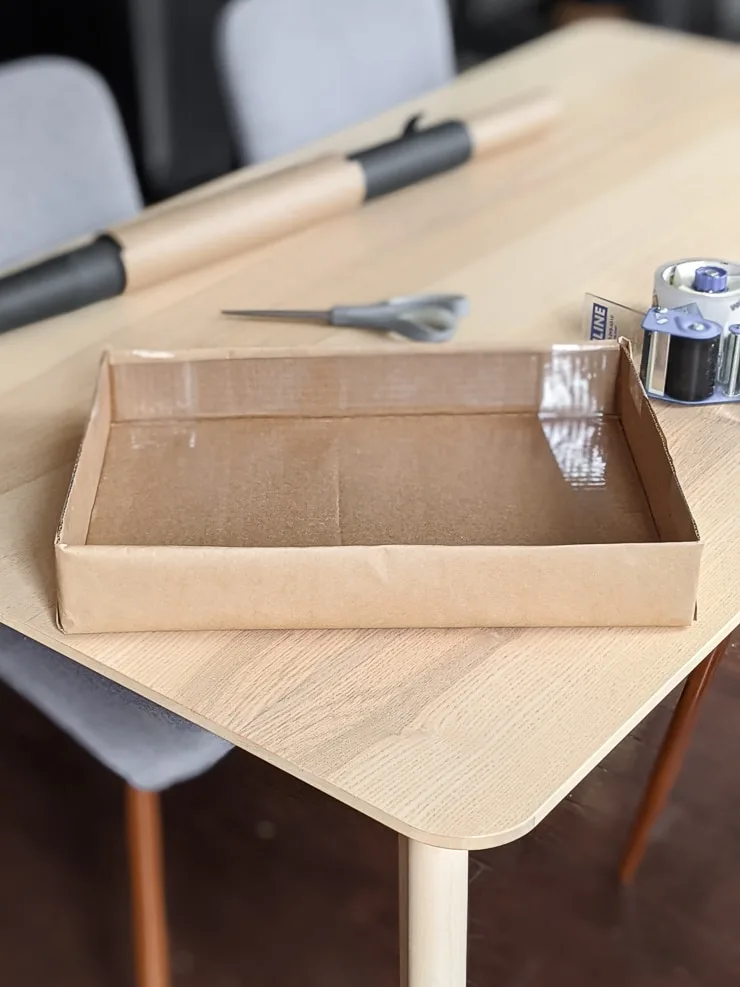 cardboard box with the top cut off on a table