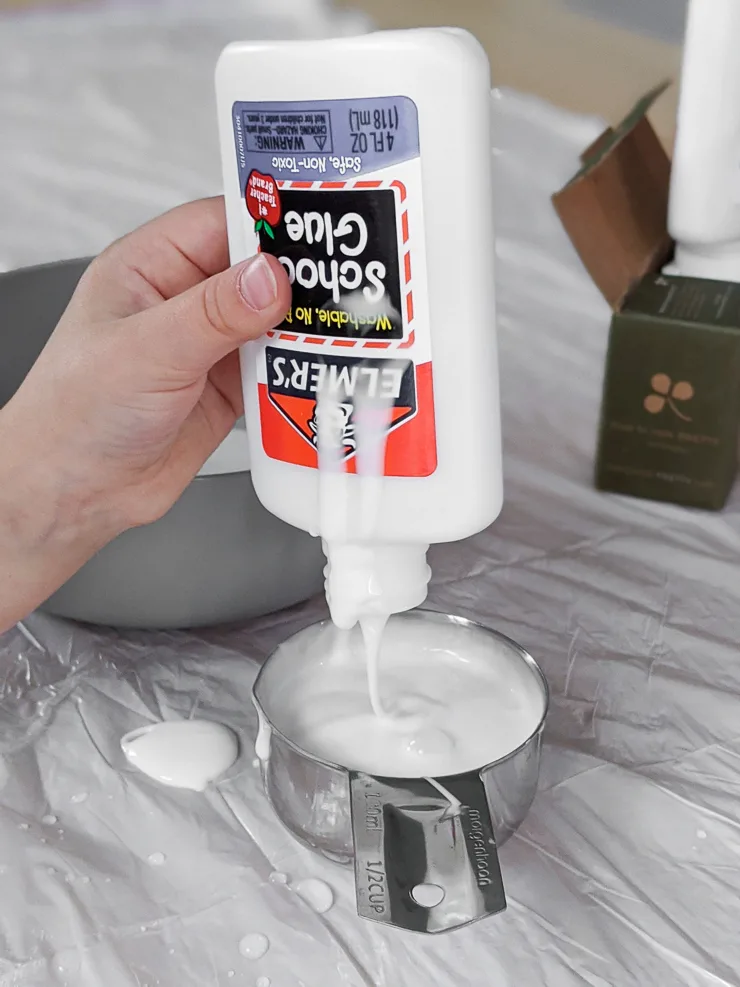 squirting glue into a measuring cup