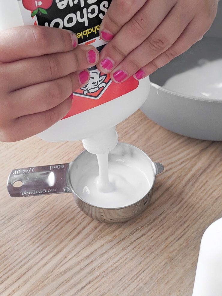 squirting glue into a measuring cup