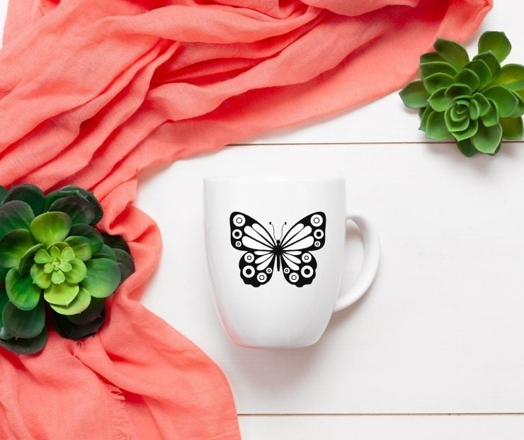 free Cricut butterfly SVG file mocked up on a coffee cup