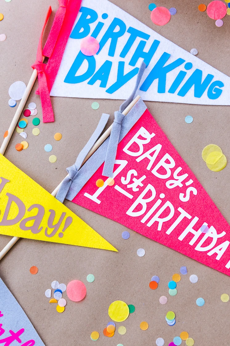 collection of colorful birthday pennants made with felt on a Cricut