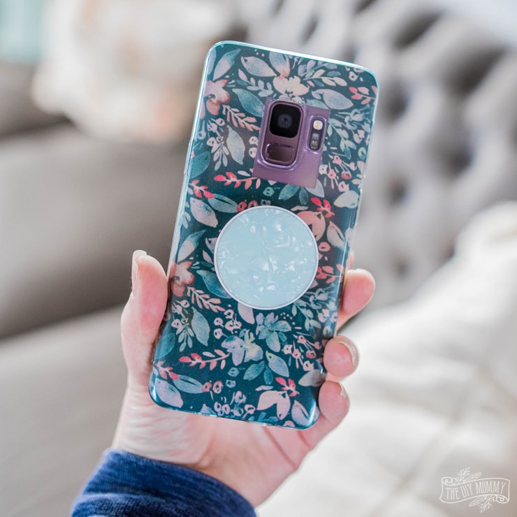 hand holding phone with floral designed phone case
