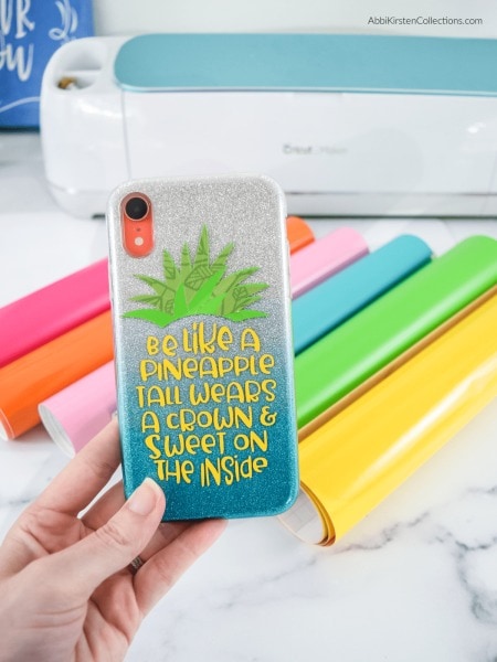 hand holding a phone case with a pineapple on it