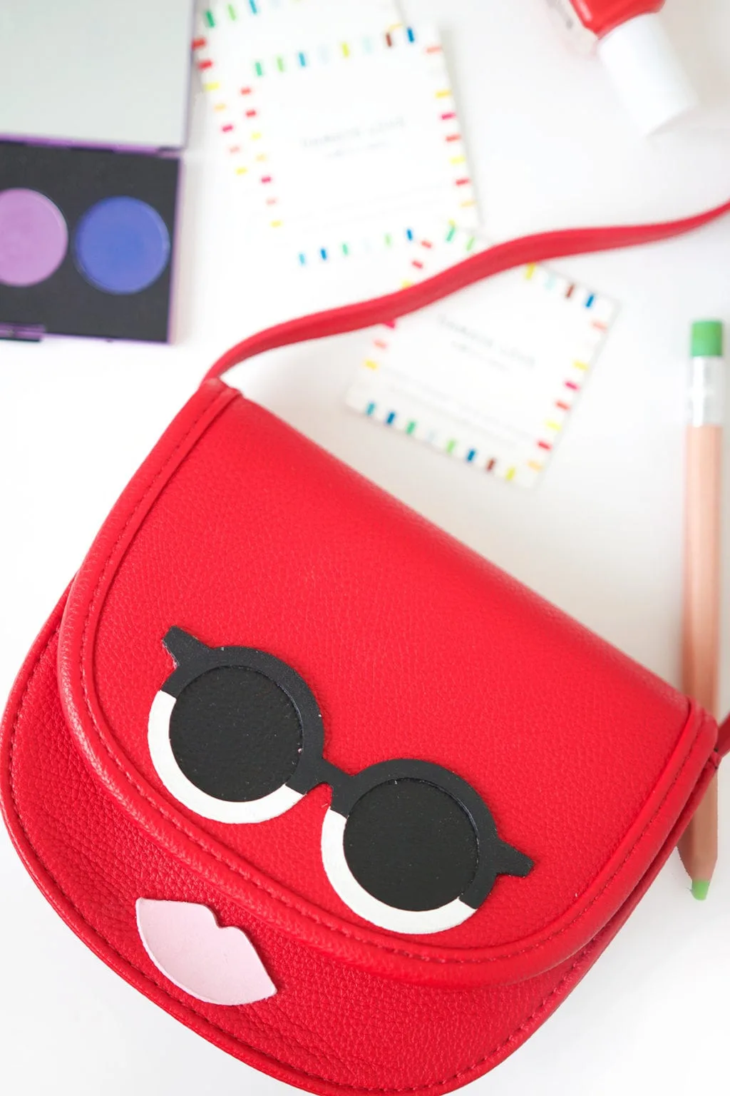 red purse with face added using leather 