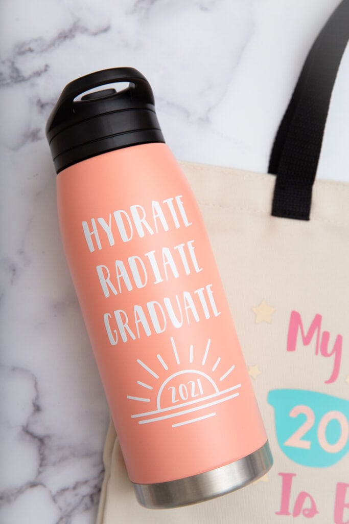 peach water bottle with hydrate, radiate, graduate text