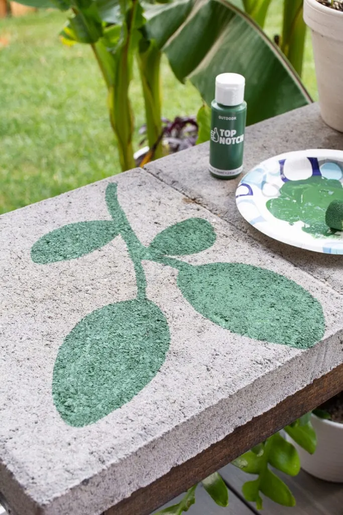 green painted leaf on a concrete paver