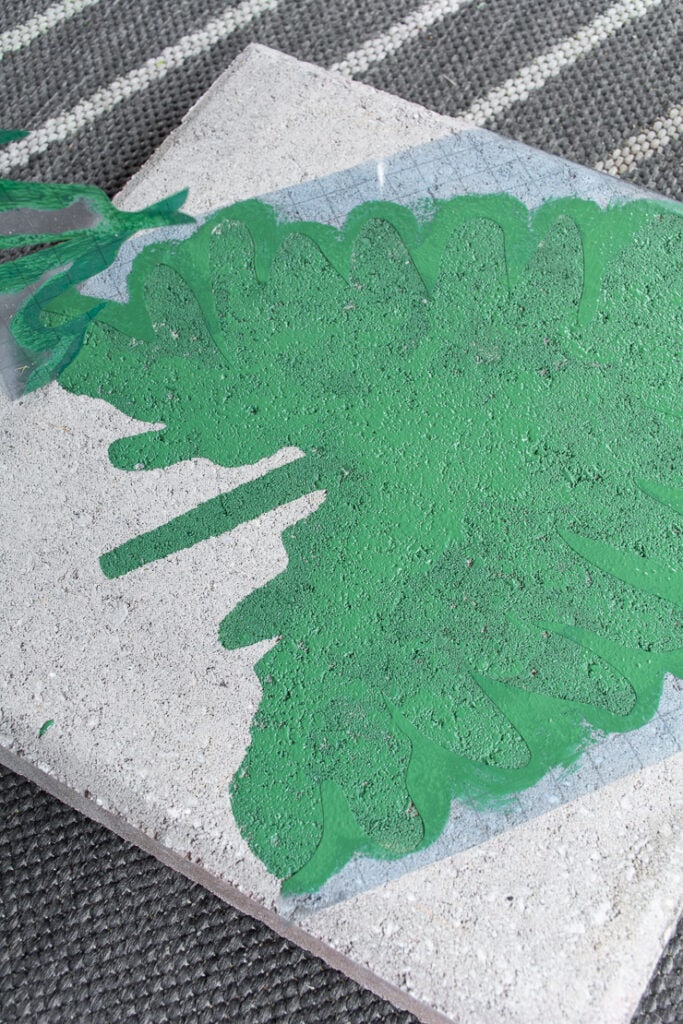 green painted leaf on a concrete paver