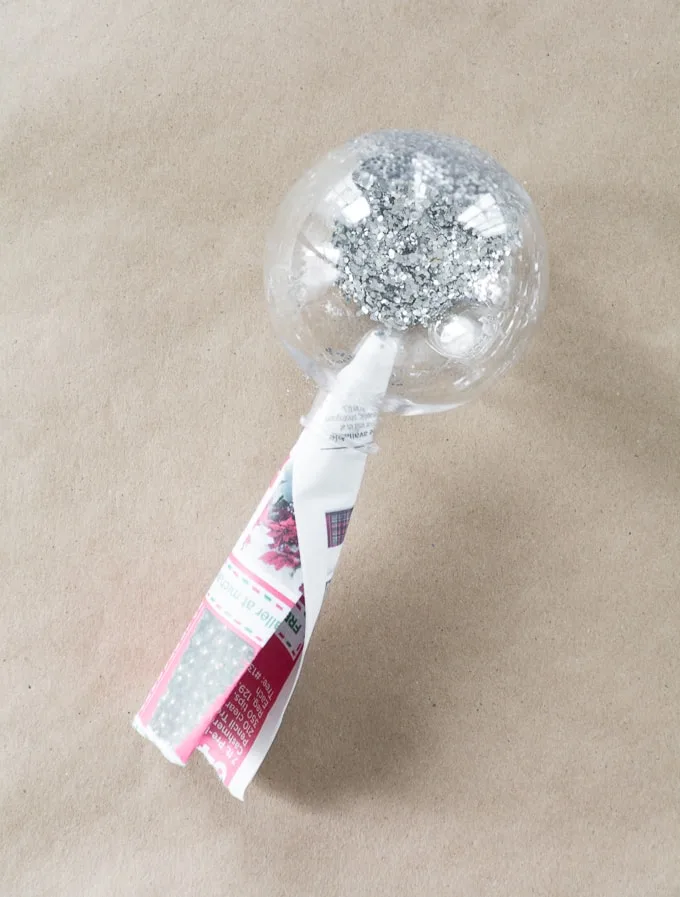 dumping glitter inside of a clear ornament