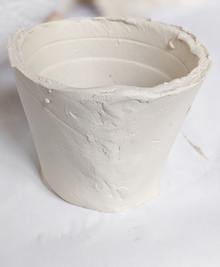 smoothing out an air dry clay pot