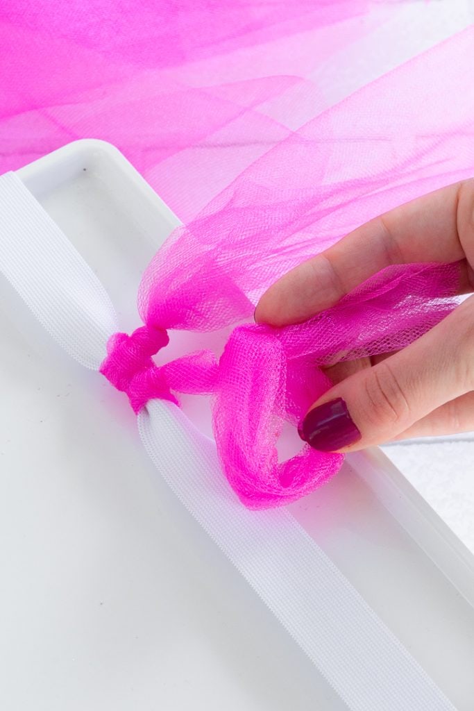 tying pieces of tulle on to make a tutu