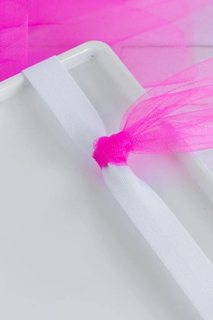 tying pieces of tulle on to make a tutu