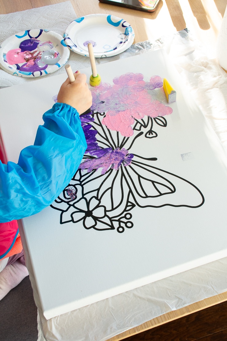 kid painting on a canvas