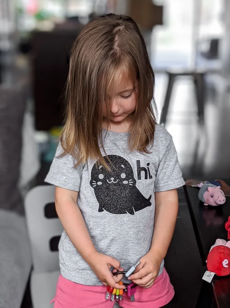 little girl with a personalized shirt made using Cricut