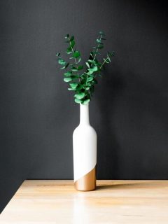 wine bottle vase on table against black wall