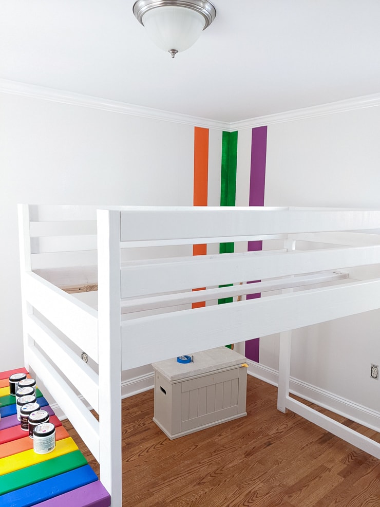 orange, green, and purple stripes painted on a white wall