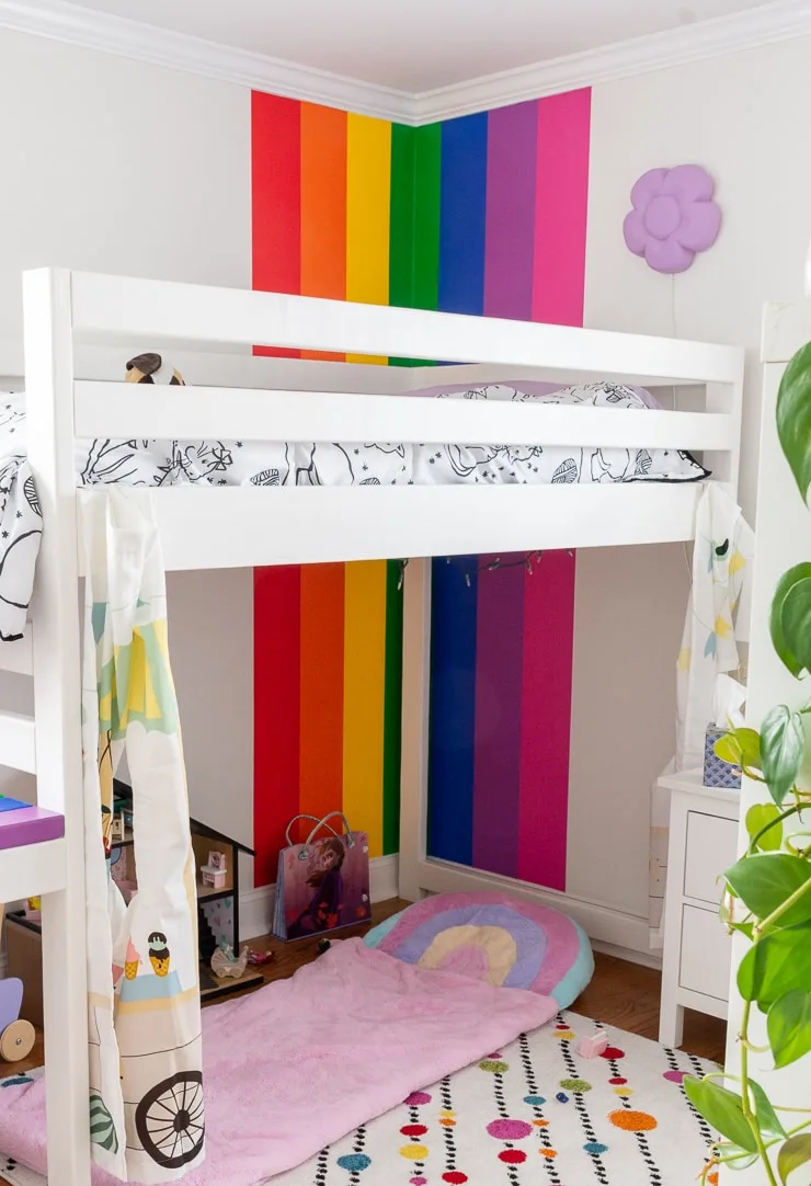 gorgeous kids room with a rainbow painted accent wall