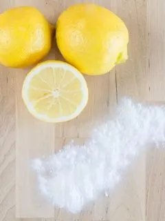 three lemons and baking soda on a wooden background