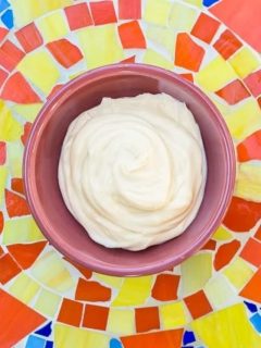 whipped body butter in a pink bowl on a mosaic background