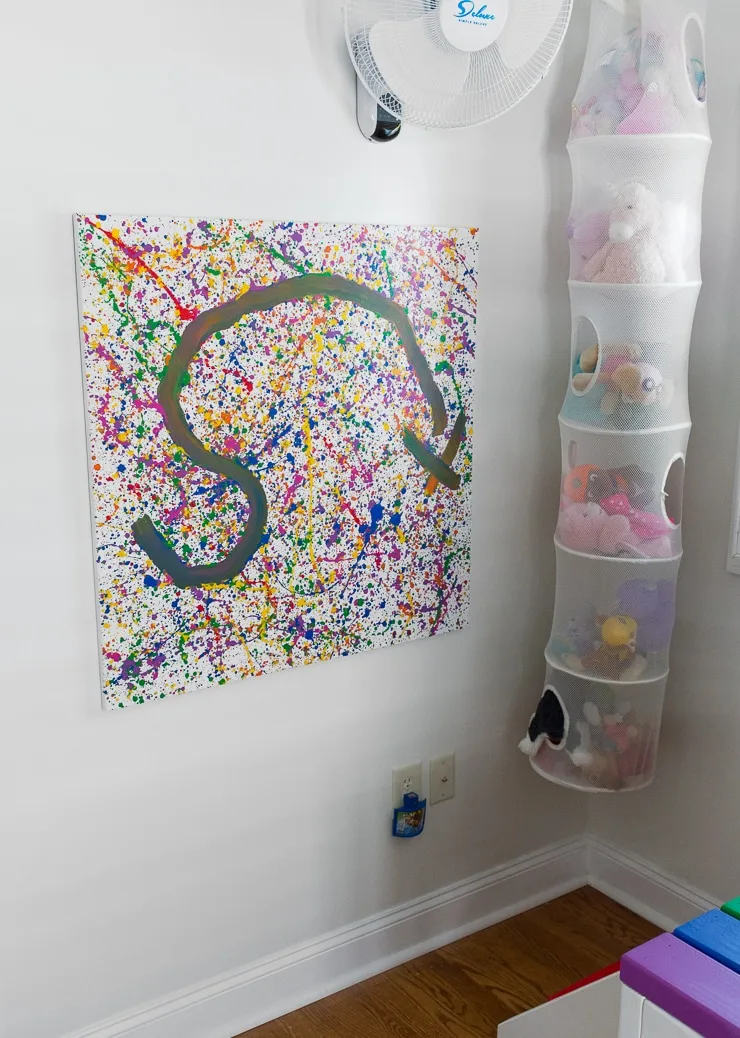 rainbow splatter paint art on a bedroom wall