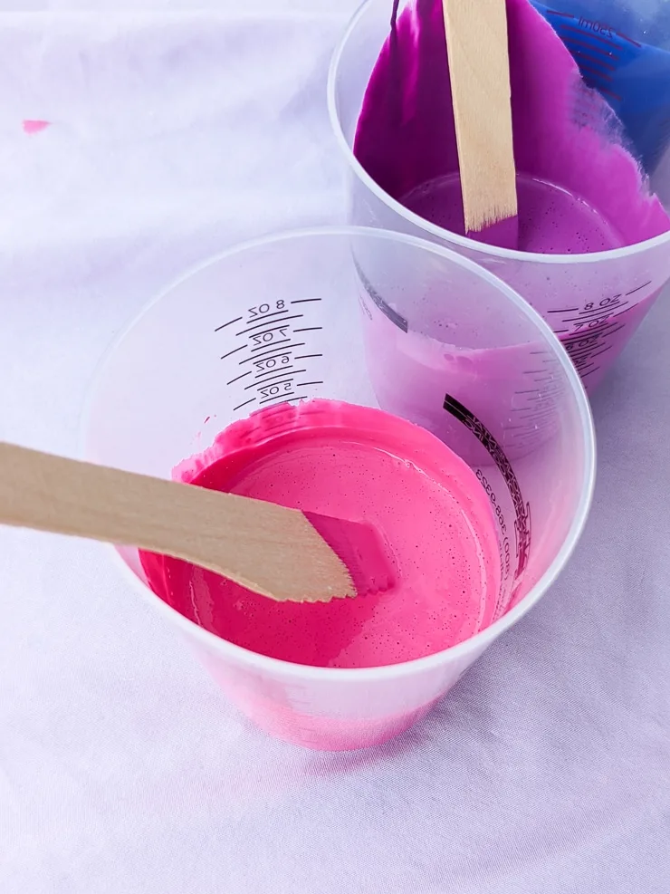 pink and purple paint in cups