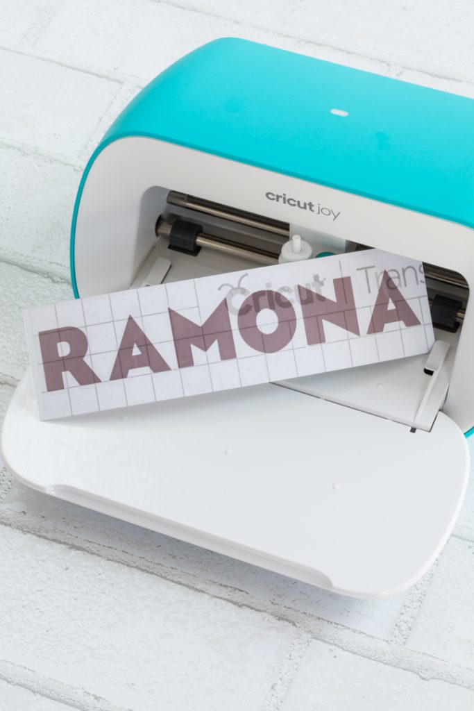 Cricut Joy with the name RAMONA cut out of vinyl