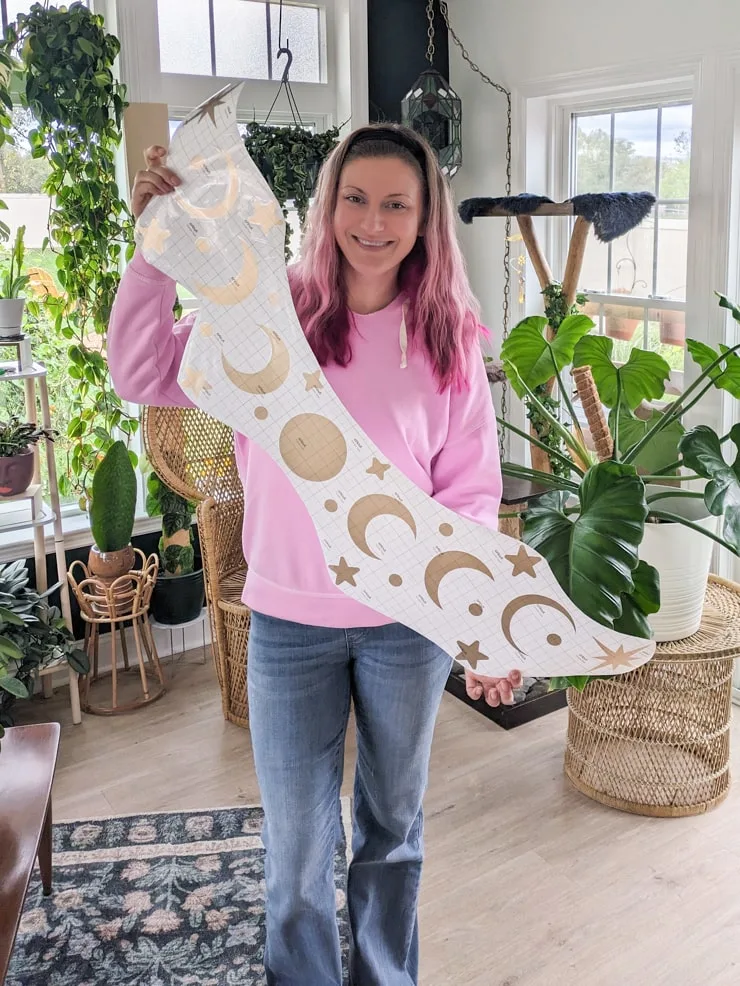 woman holding a large moon phase decal that was cut on a Cricut Venture